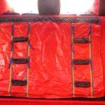 Red inflatable obstacle course structure with black rectangular sections and climbing elements visible against bright sky