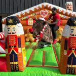 Inflatable Christmas display with nutcracker soldiers, snowmen, and reindeer on green lawn